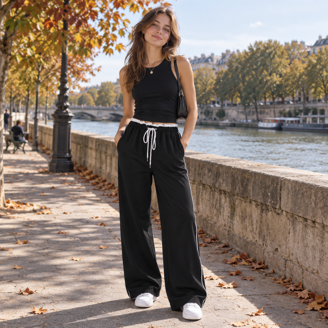 Pantaloni neri a vita arricciata con bordo bianco a contrasto e sneakers bianche