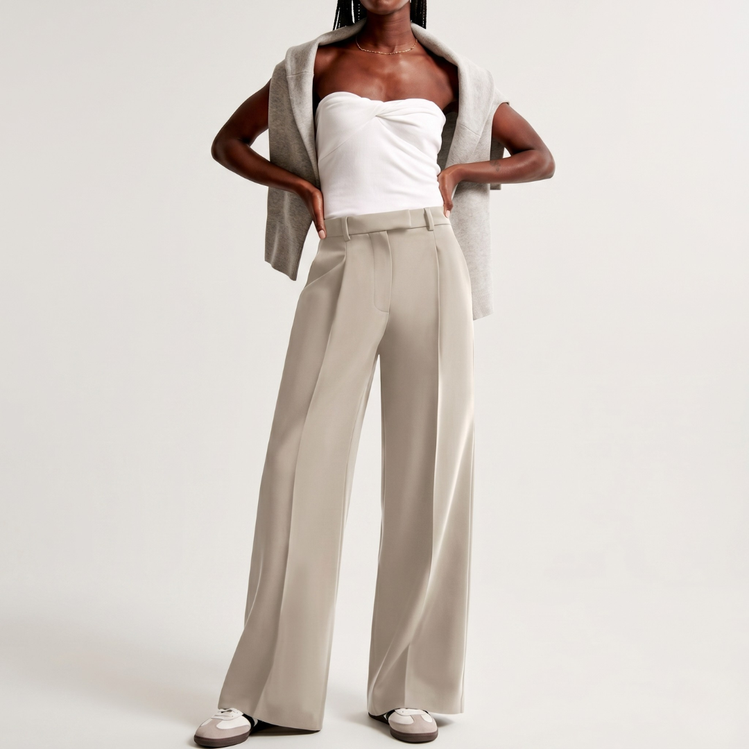 Look intero con pantaloni beige a gamba larga, top bianco e sneakers chiare
