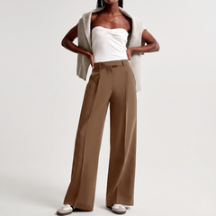 Look intero con pantaloni cammello, top bianco e maglia annodata sulle spalle