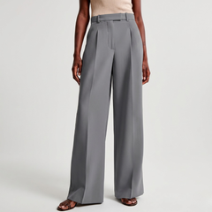 Dettaglio dei pantaloni grigio chiaro con piega centrale e orlo ampio