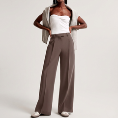 Outfit completo con pantaloni tortora, top bianco annodato e sneakers basse