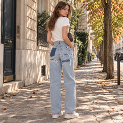 Retro dei pantaloni donna blu con strappi e inserti a contrasto sotto le tasche
