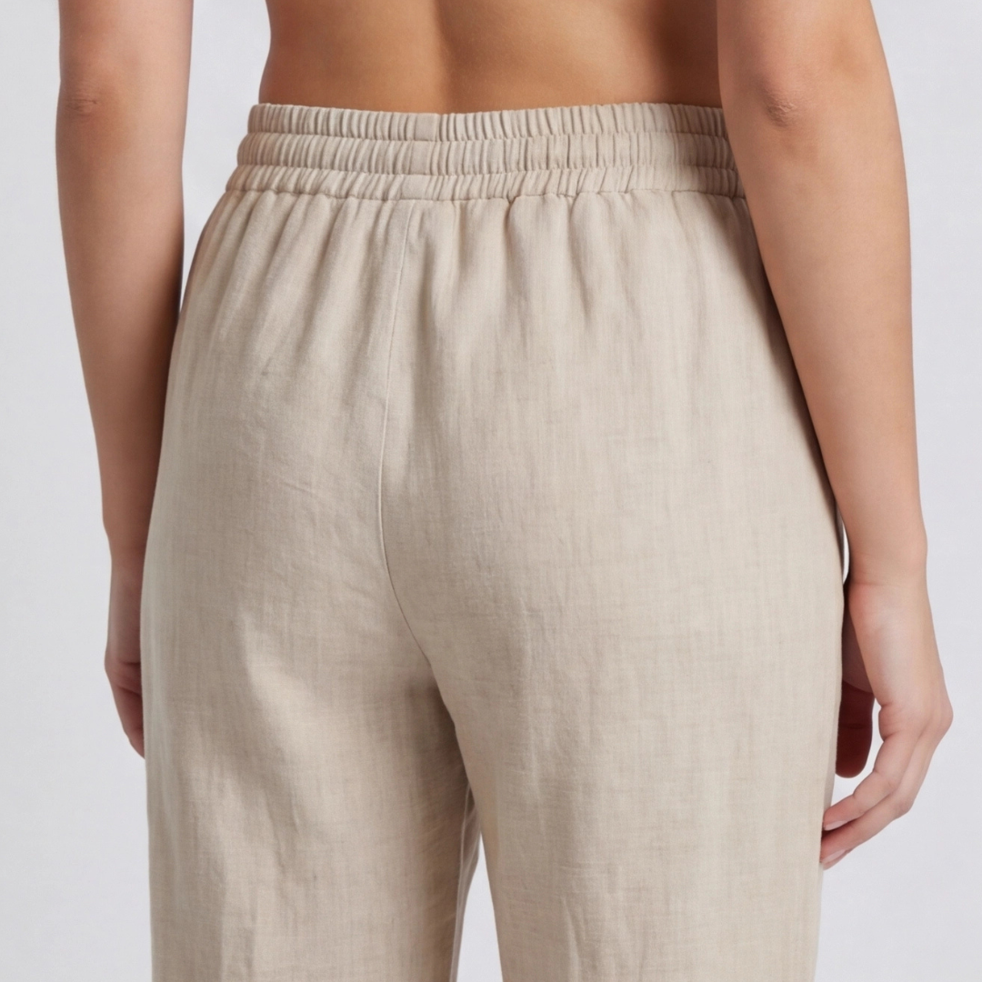Dettaglio posteriore dei pantaloni beige con vita elastica arricciata e cucitura centrale