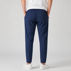 Pantaloni uomo blu scuro di spalle, vita arricciata elastica e gamba dritta affusolata