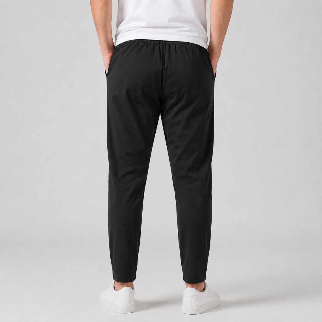 Pantaloni uomo neri visti di spalle, vita elastica e linea affusolata verso la caviglia