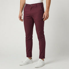 Pantaloni uomo chino bordeaux slim fit abbinati a sneakers bianche, fondo risvoltato