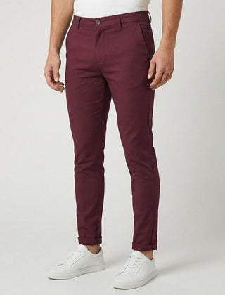 Pantaloni uomo chino bordeaux slim fit abbinati a sneakers bianche, fondo risvoltato