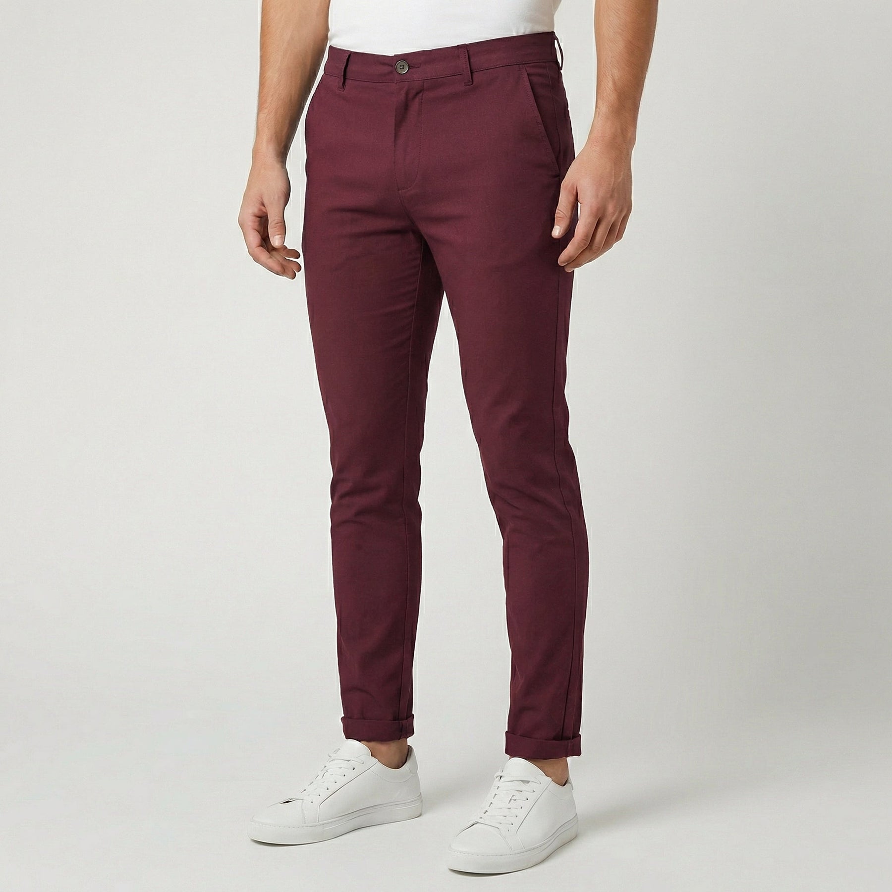 Pantaloni uomo chino bordeaux slim fit abbinati a sneakers bianche, fondo risvoltato