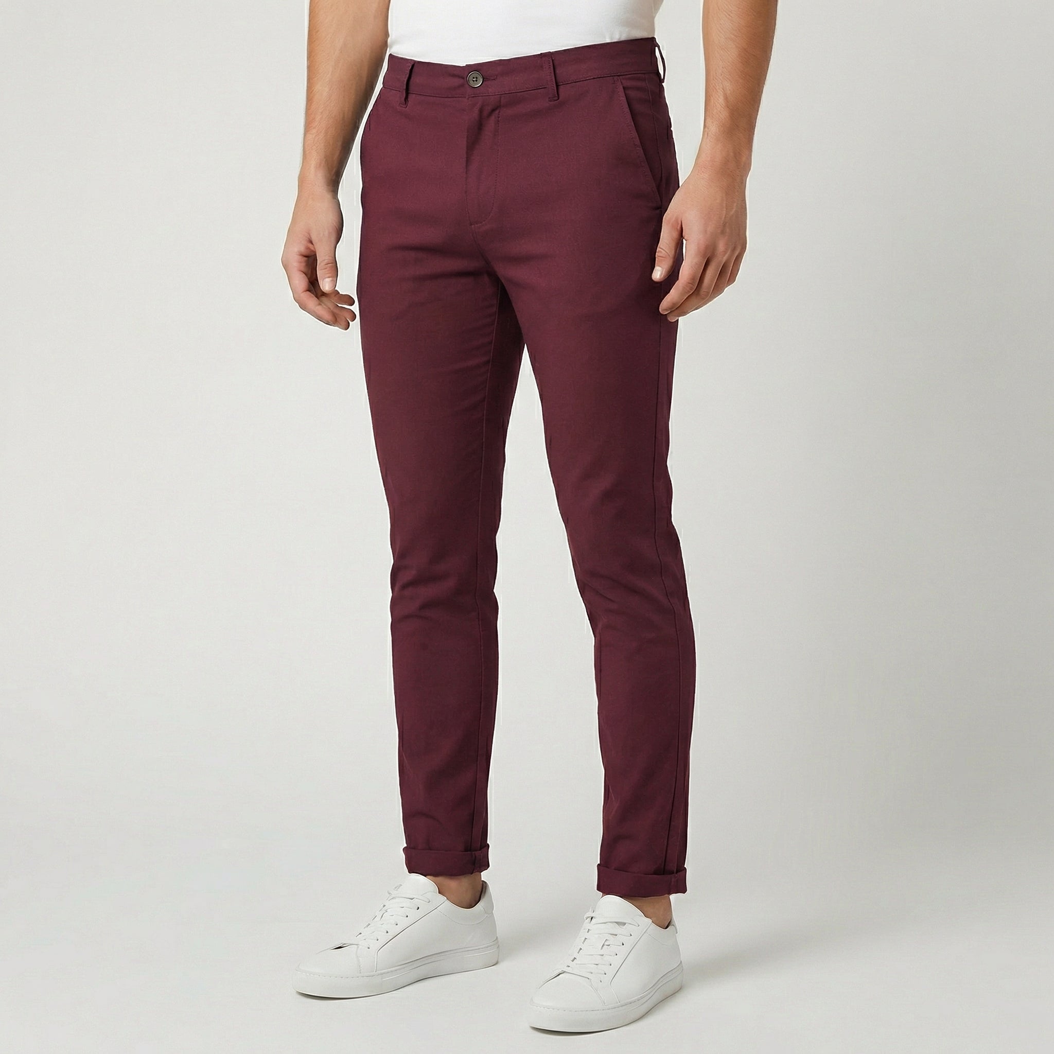 Pantaloni uomo chino bordeaux slim fit abbinati a sneakers bianche, fondo risvoltato