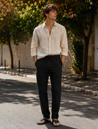 Pantaloni uomo neri con coulisse annodata, camicia beige e sandali
