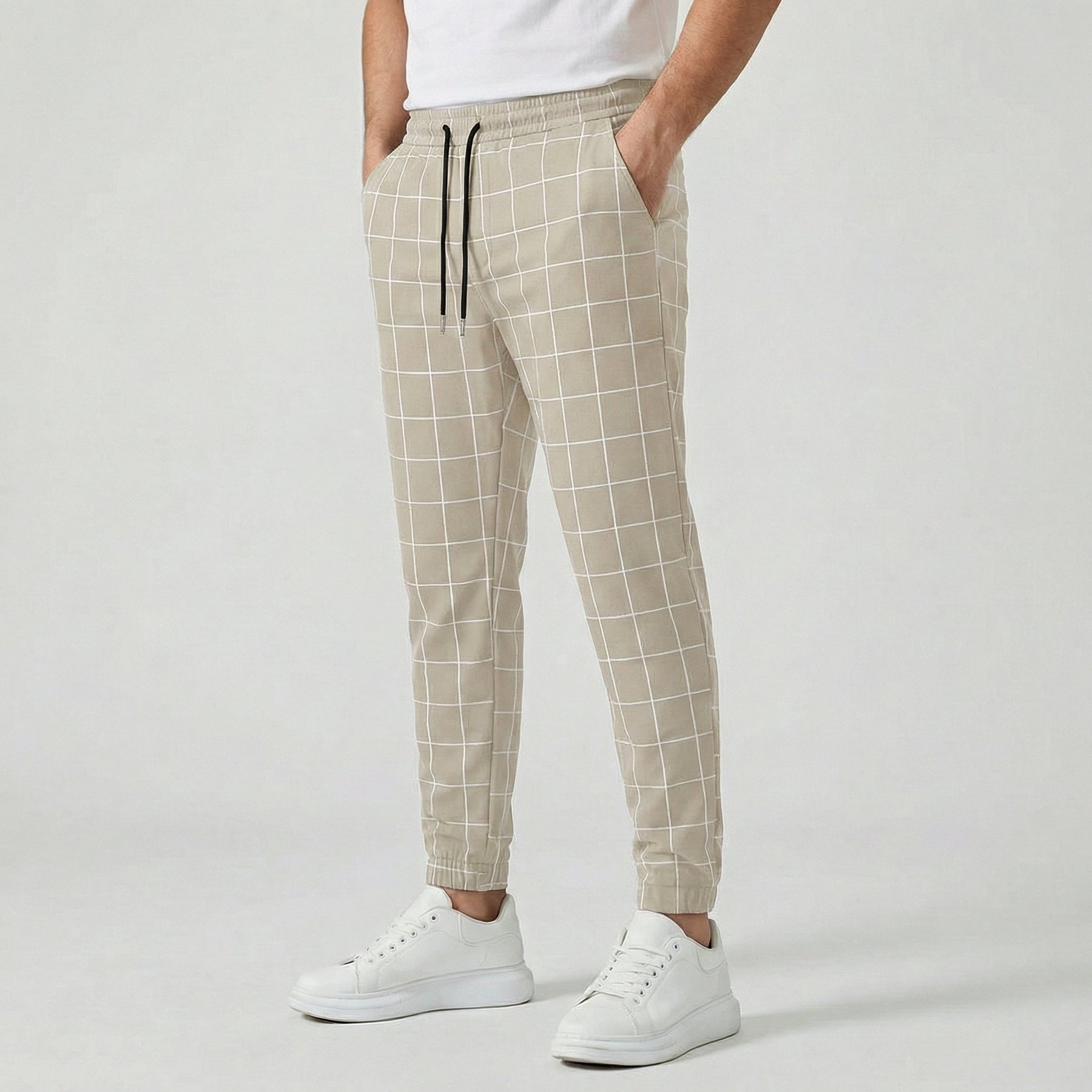 Pantaloni uomo beige a quadri con coulisse nera a contrasto e linea affusolata