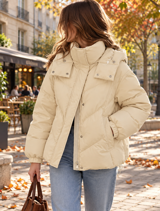 Piumino donna beige con collo alto, cappuccio e trapuntatura a chevron