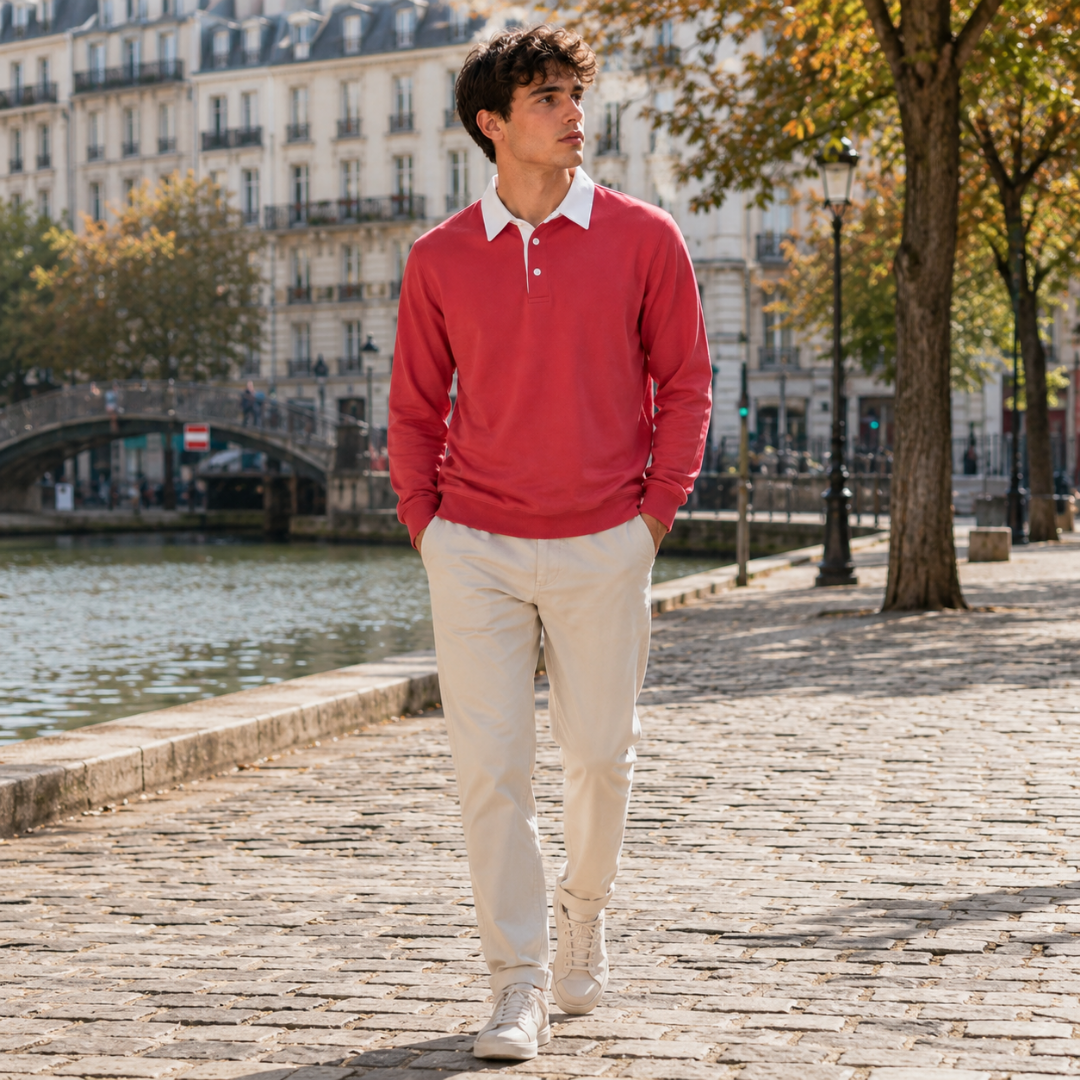 Polo rossa da uomo indossata con pantaloni chiari e sneakers, figura intera