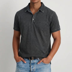Polo uomo nera effetto lavato con colletto aperto e pantaloni chiari abbinati