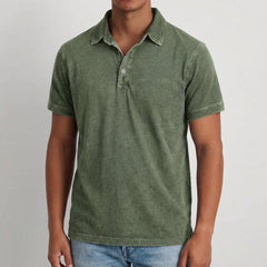 Polo uomo verde militare con maniche corte, colletto morbido e fondo leggermente arrotondato