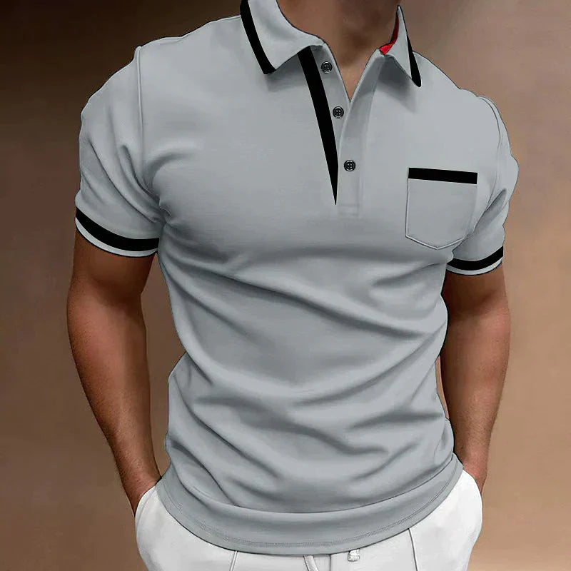 Polo uomo grigia indossata con colletto a contrasto nero e taschino sul petto