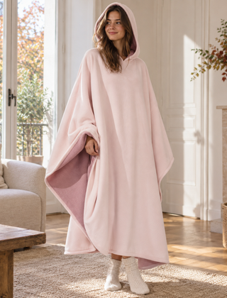 Poncho rosa con cappuccio indossato, rovescio a pelo lungo visibile sul lato