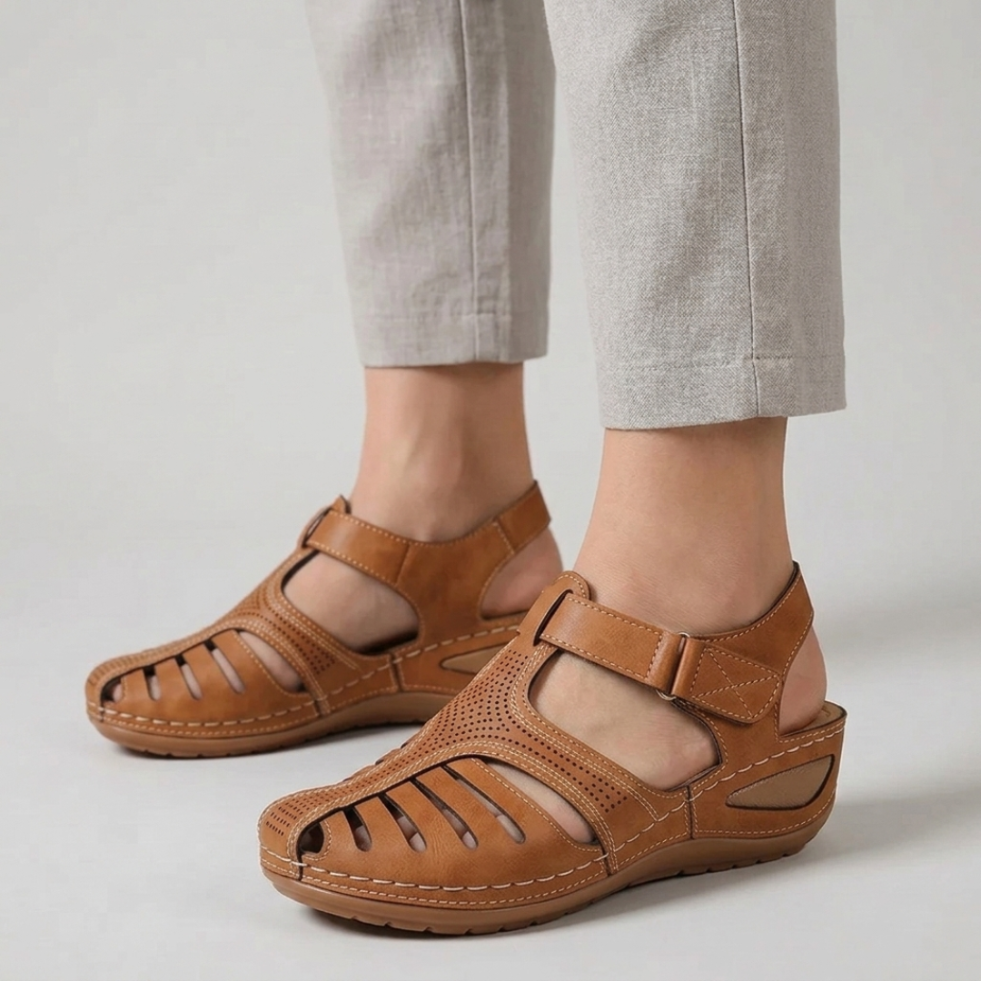 Sandali donna marroni traforati con cinturino regolabile indossati con pantaloni chiari