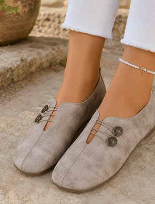 Scarpe basse donna beige con elastici incrociati e due bottoni decorativi sul collo del piede