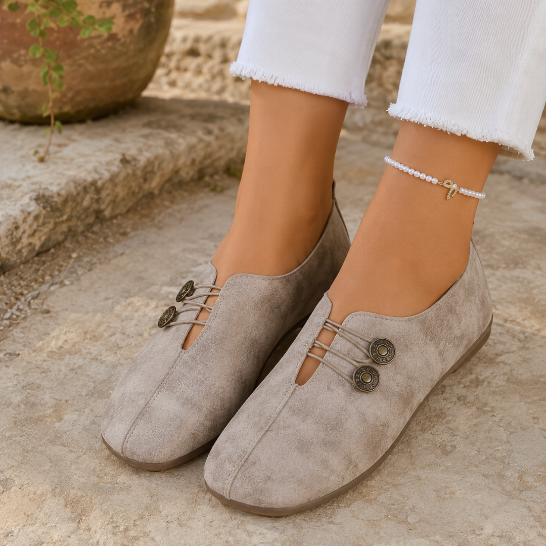 Scarpe basse donna beige con elastici incrociati e due bottoni decorativi sul collo del piede