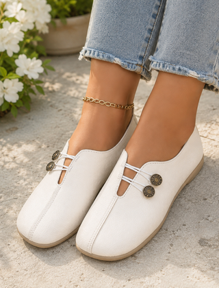 Scarpe basse donna bianche con elastici chiari e bottoni decorativi, con pantaloni azzurri