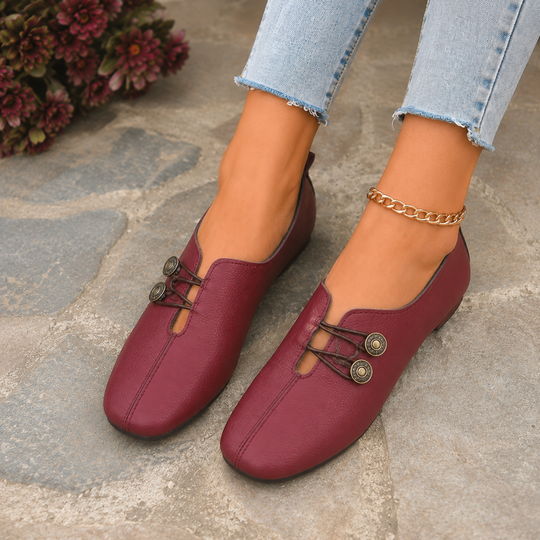 Scarpe basse bordeaux dall'alto con due bottoni decorativi in metallo anticato