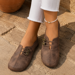 Scarpe basse donna marroni sfumate con bottoni decorativi, abbinate a pantaloni bianchi