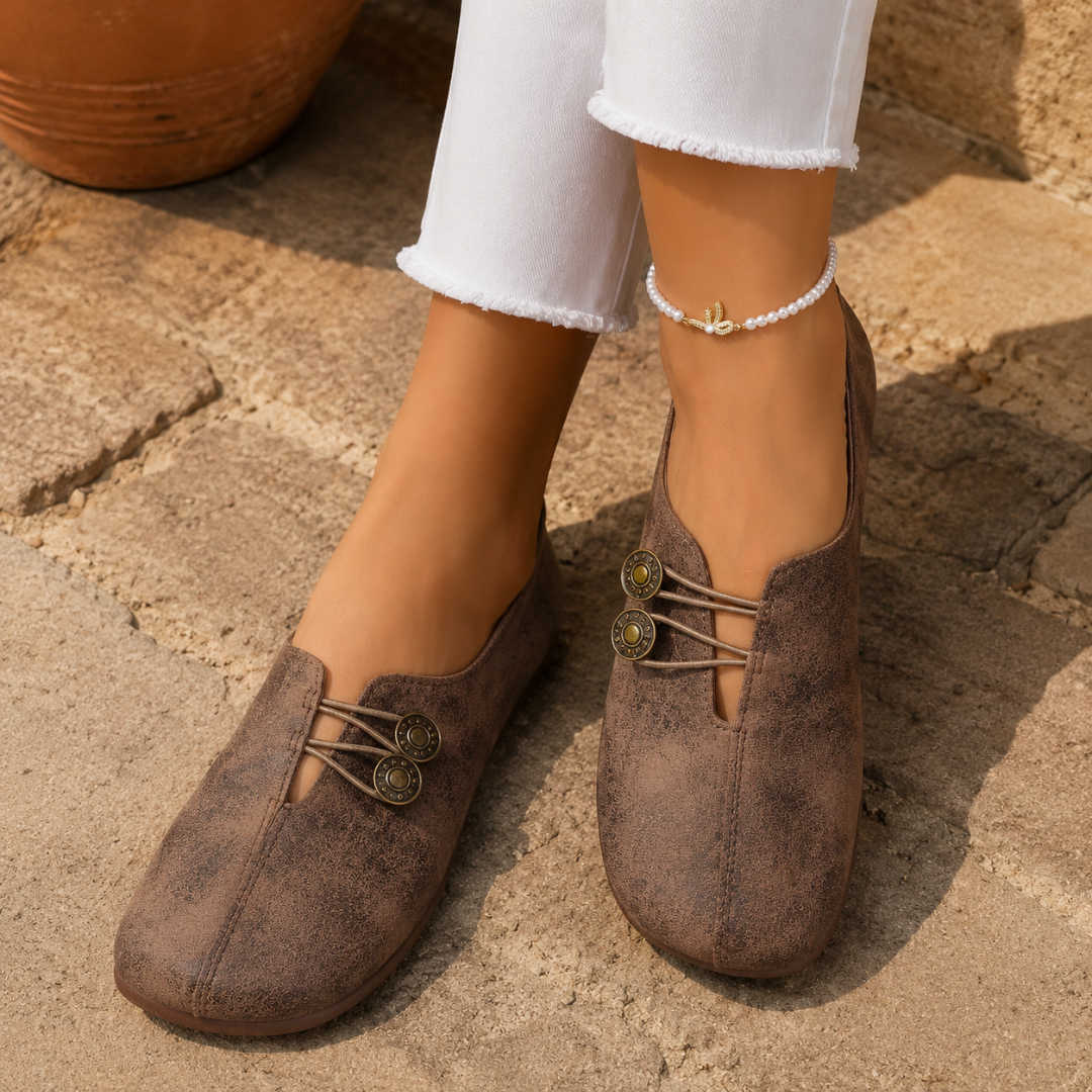 Scarpe basse donna marroni sfumate con bottoni decorativi, abbinate a pantaloni bianchi