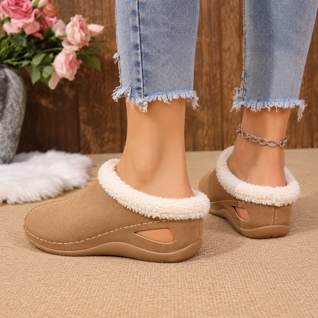Dettaglio laterale delle scarpe marroni con zeppa e bordo effetto pelliccia