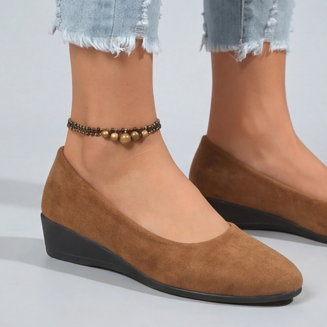 Dettaglio laterale della zeppa bassa nera su scarpe donna color cammello
