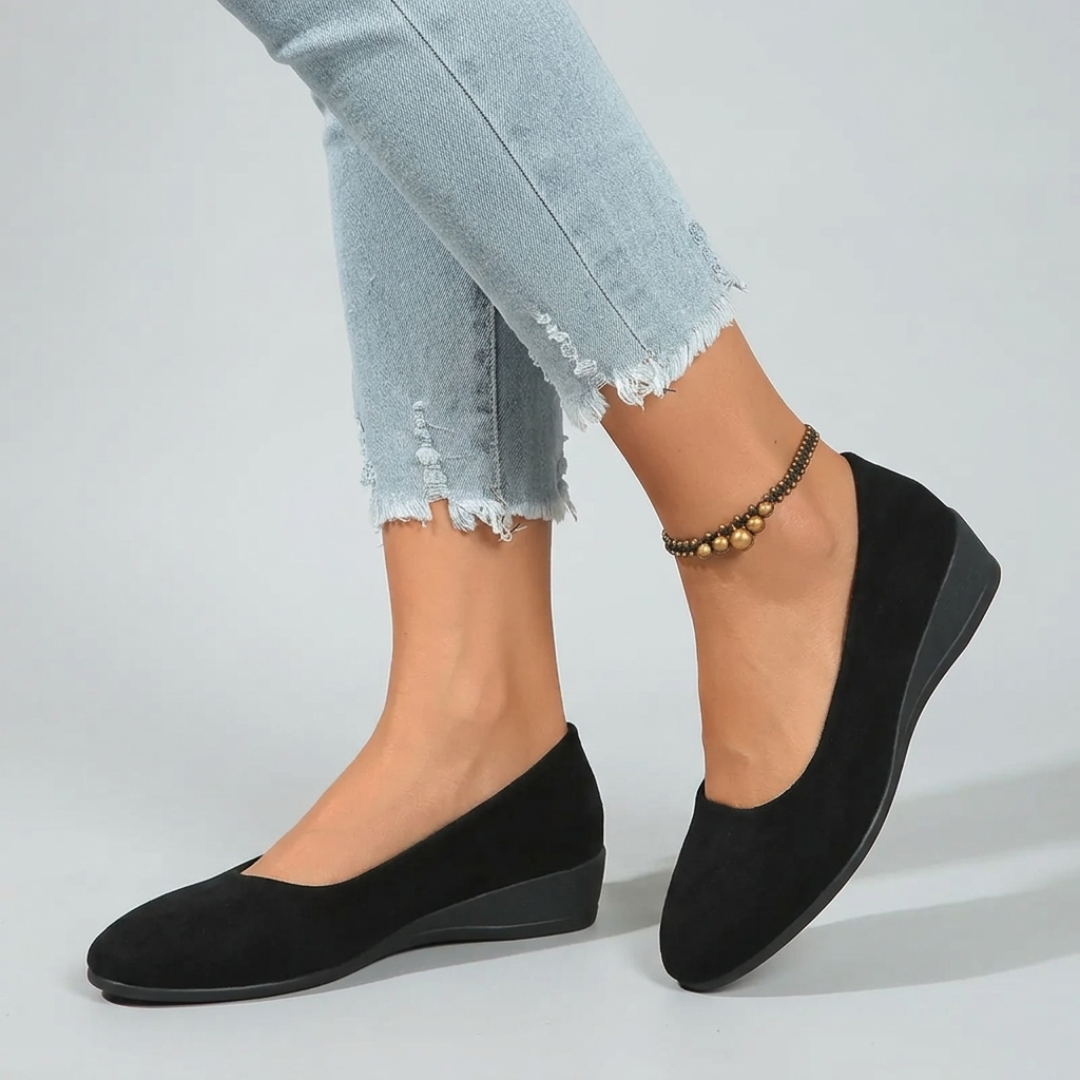 Scarpe donna nere slip-on con zeppa bassa abbinate a pantaloni sfrangiati chiari