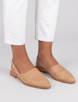 Slingback beige intrecciate con cinturino posteriore, indossate con pantaloni bianchi