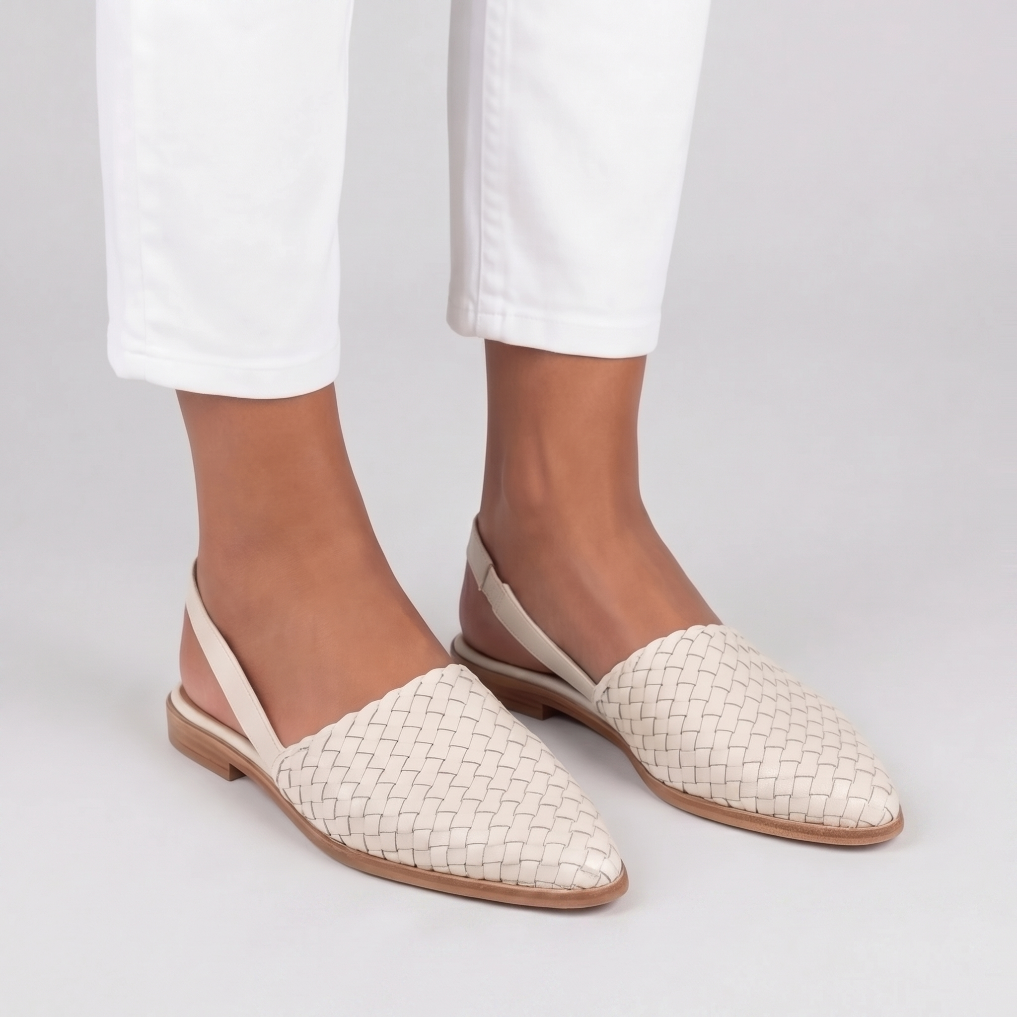Slingback bianche intrecciate con cinturino posteriore e suola chiara, look estivo