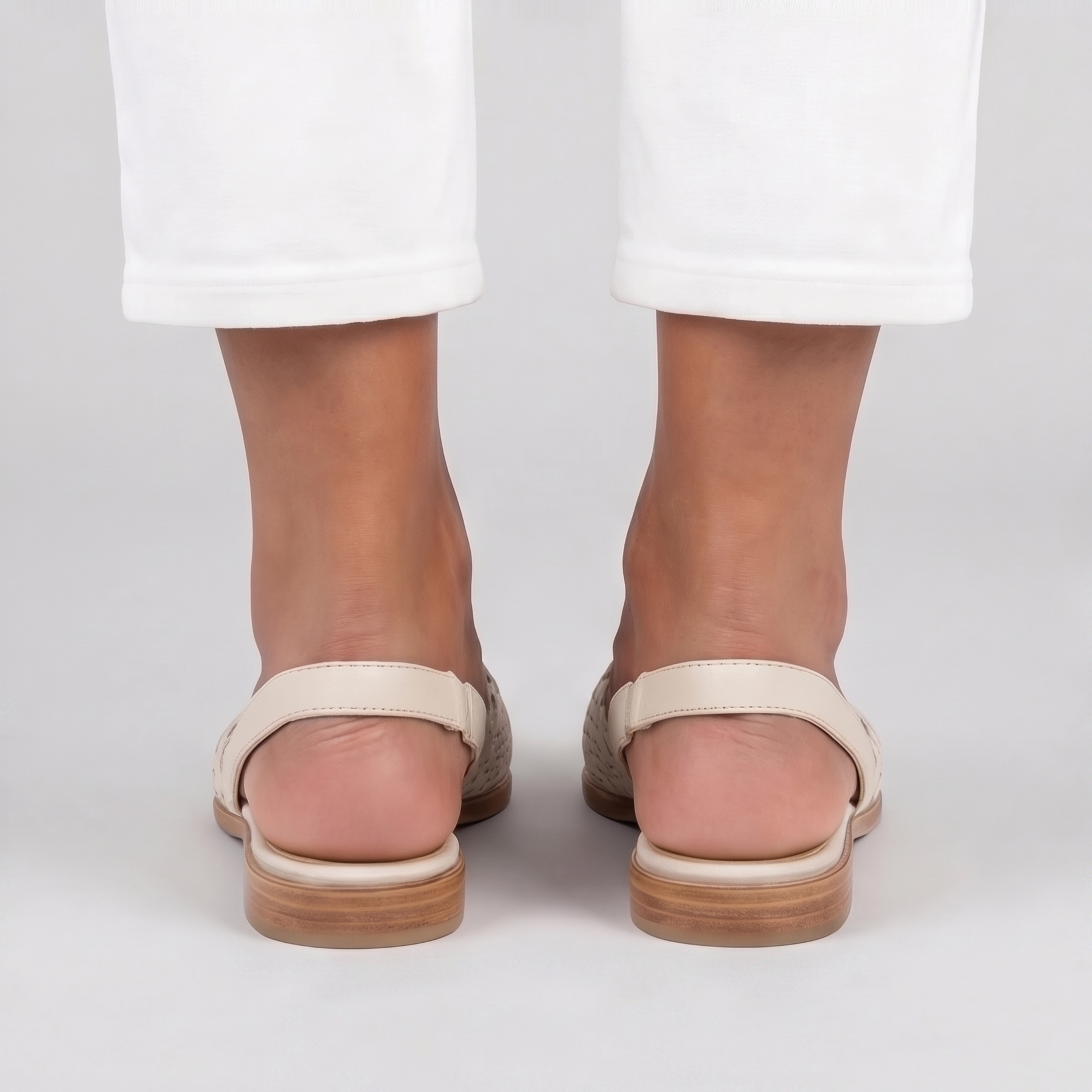 Vista posteriore delle slingback bianche con cinturino piatto e impunture sul tallone