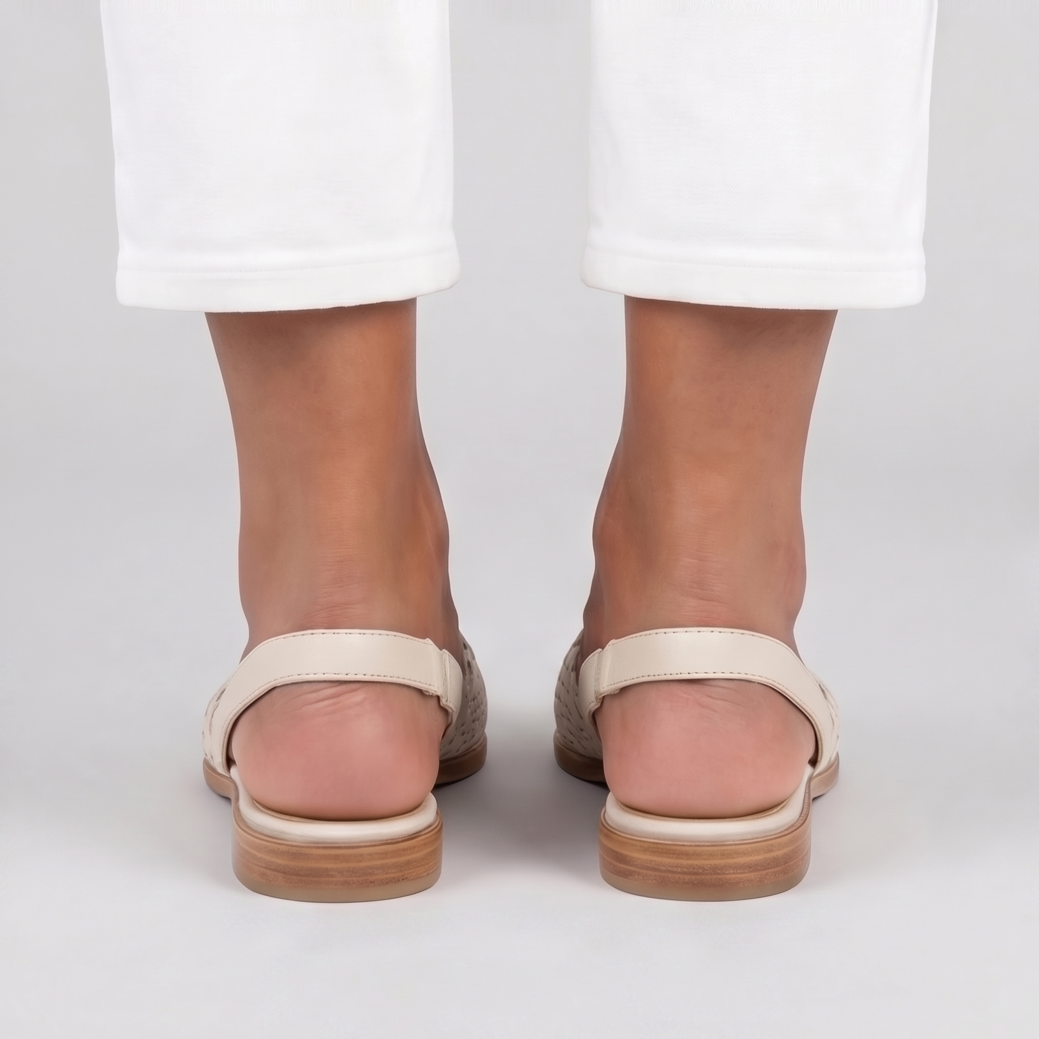 Vista posteriore delle slingback bianche con cinturino piatto e impunture sul tallone