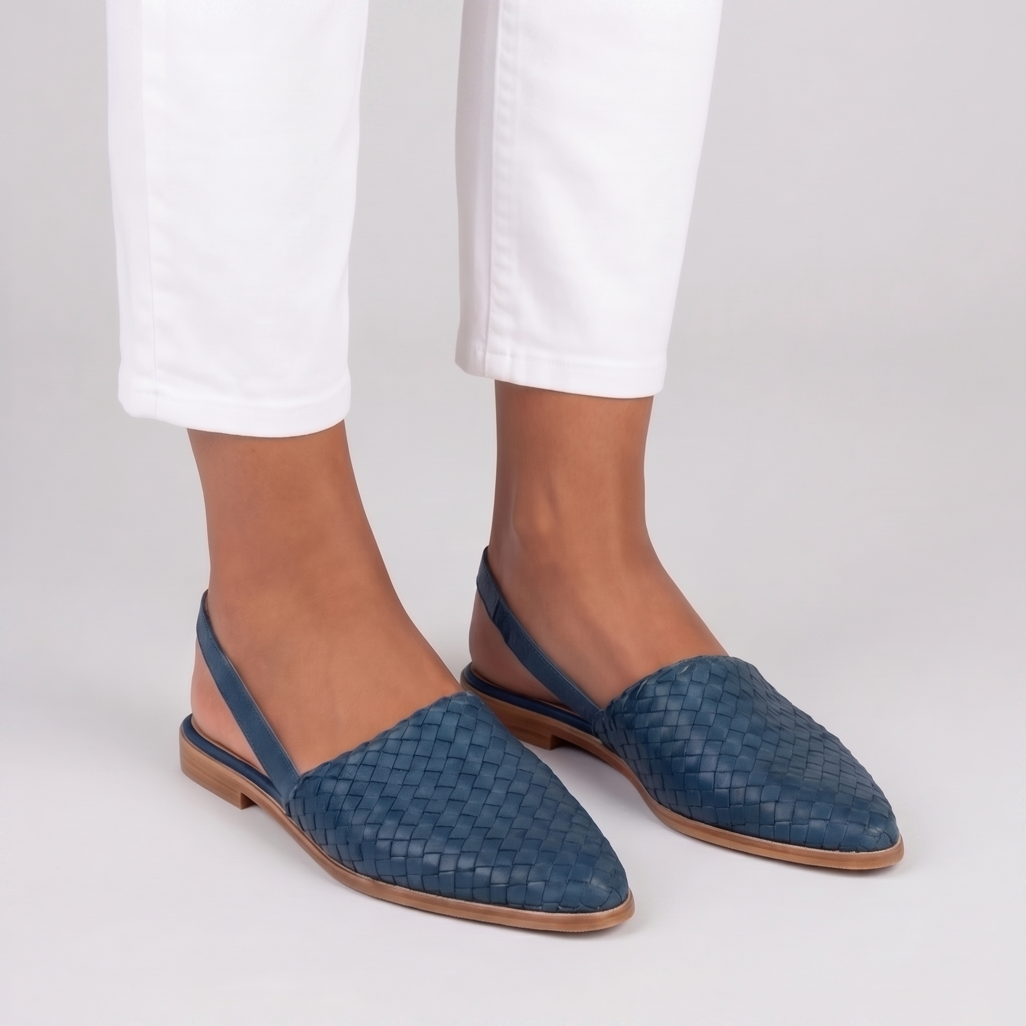Slingback blu intrecciate con cinturino posteriore, abbinate a pantaloni bianchi