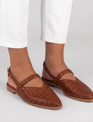 Slingback marroni effetto intrecciato indossate con pantaloni bianchi e cinturino posteriore con fibbia