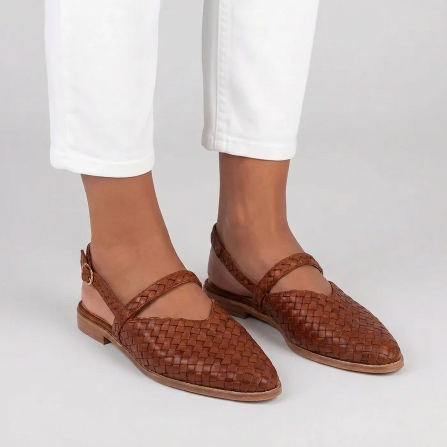 Slingback marroni effetto intrecciato indossate con pantaloni bianchi e cinturino posteriore con fibbia