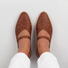 Vista dall'alto delle slingback marroni intrecciate con punta affusolata e fascetta sul piede