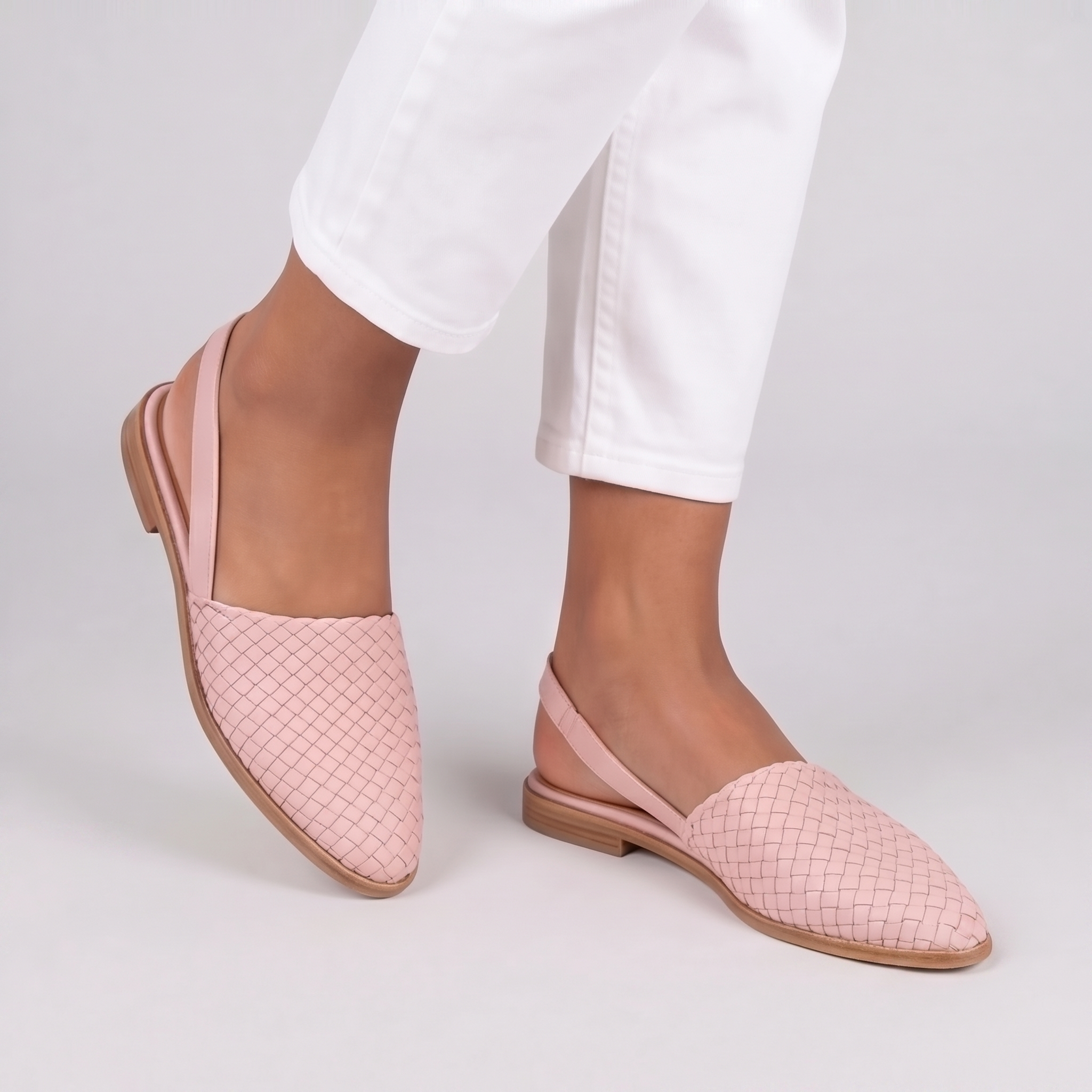 Slingback rosa in movimento con tomaia intrecciata e cinturino posteriore sottile