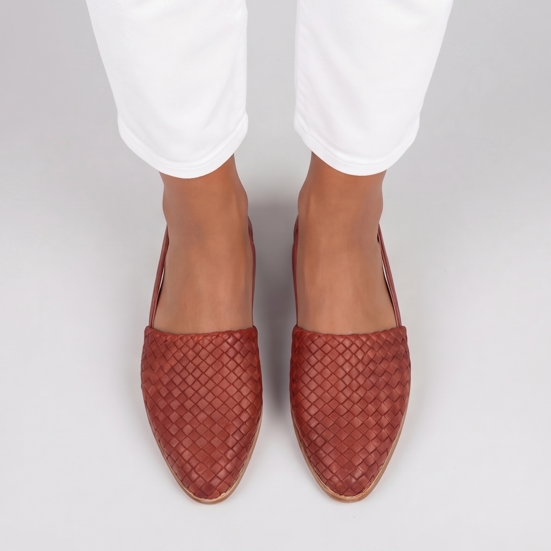 Vista dall'alto delle slingback rosse con intreccio fitto sulla punta