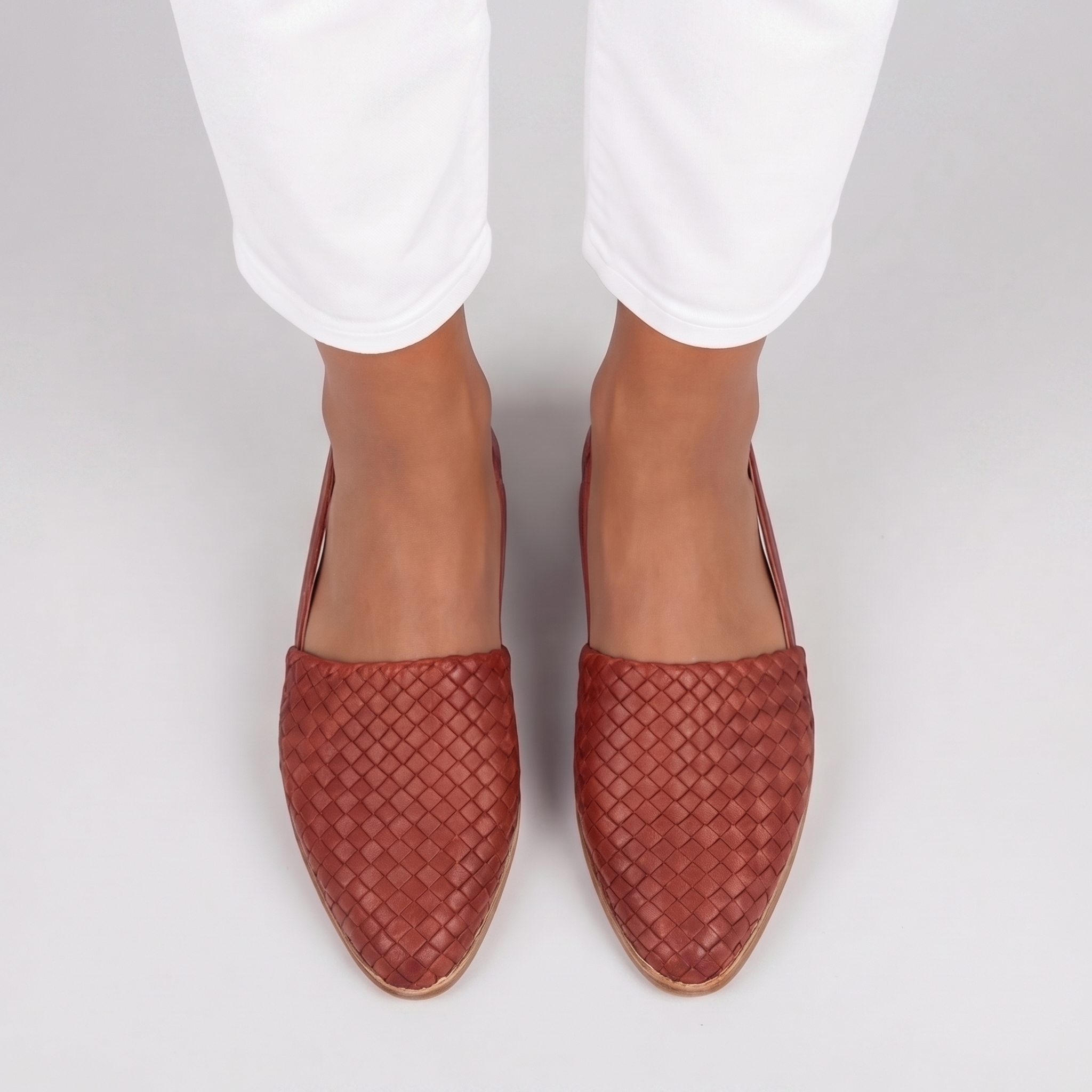 Vista dall'alto delle slingback rosse con intreccio fitto sulla punta