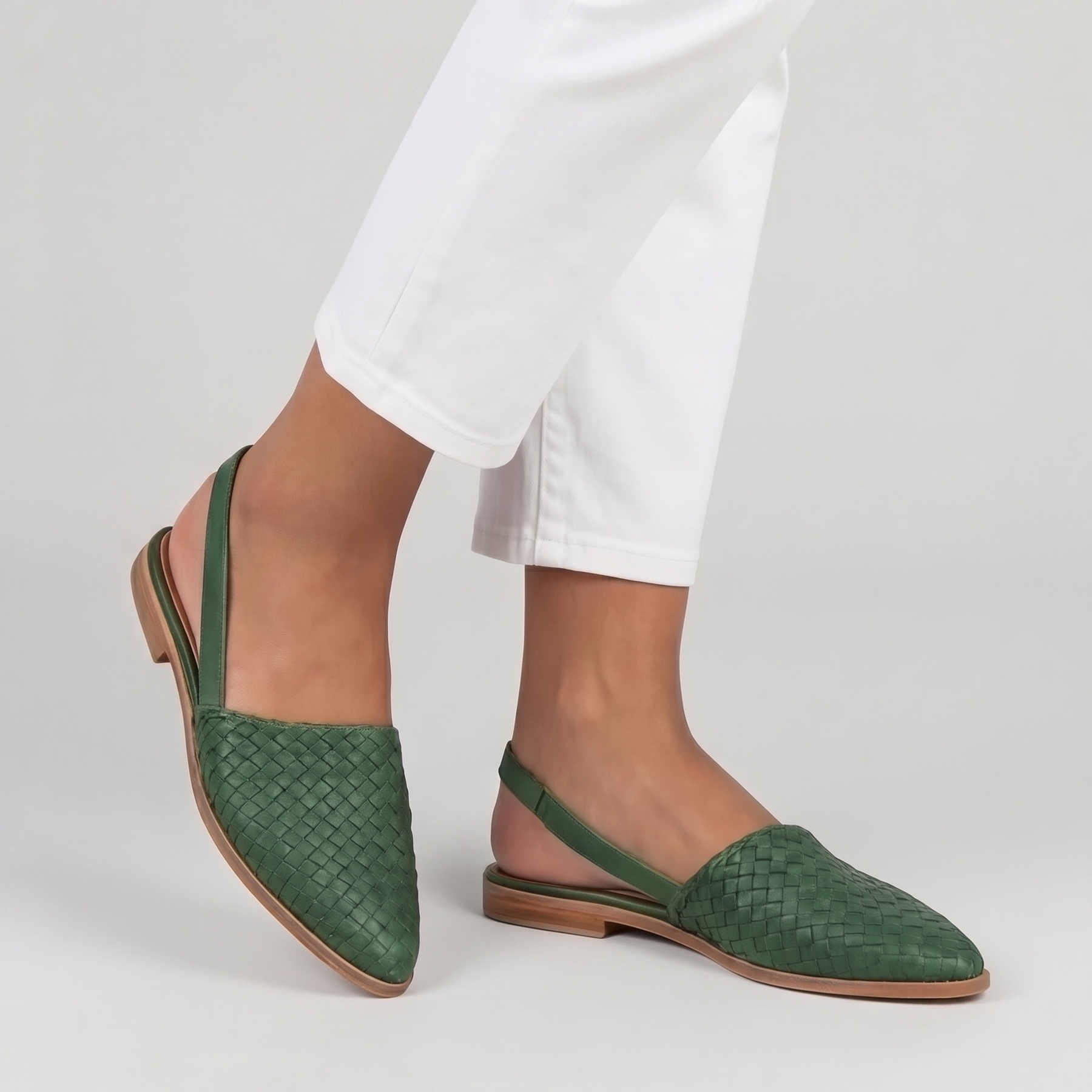 Slingback verdi in movimento con tomaia intrecciata e suola chiara