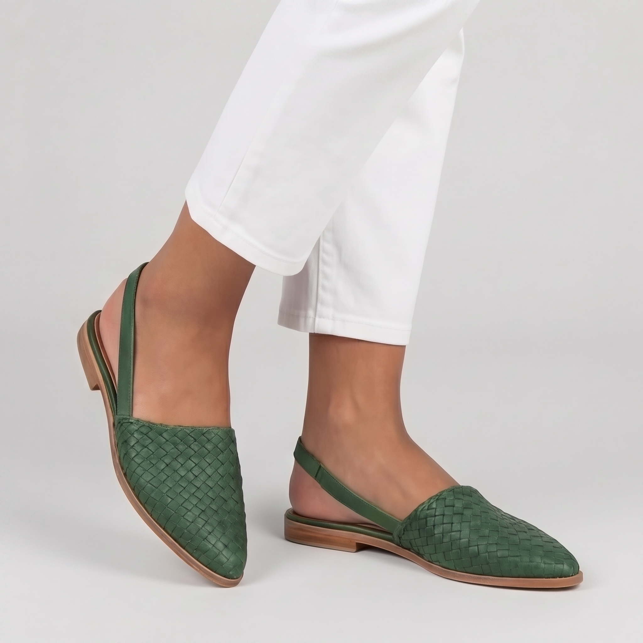 Slingback verdi in movimento con tomaia intrecciata e suola chiara