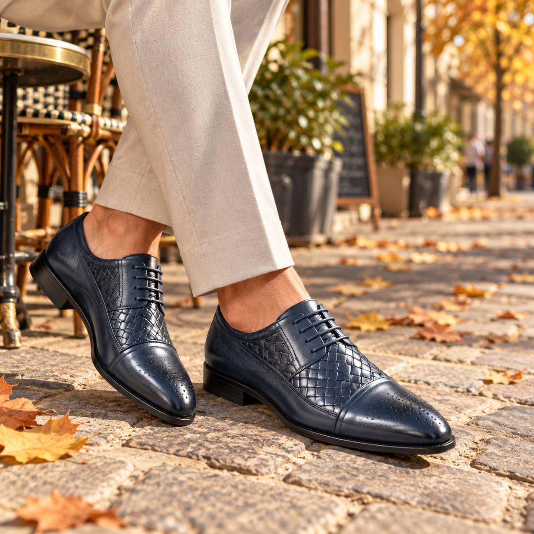 Scarpe stringate uomo blu con inserto intrecciato e punta traforata, indossate su pavé