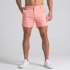 Shorts uomo rosa con orlo risvoltato e tasche laterali, abbinati a sneakers bianche