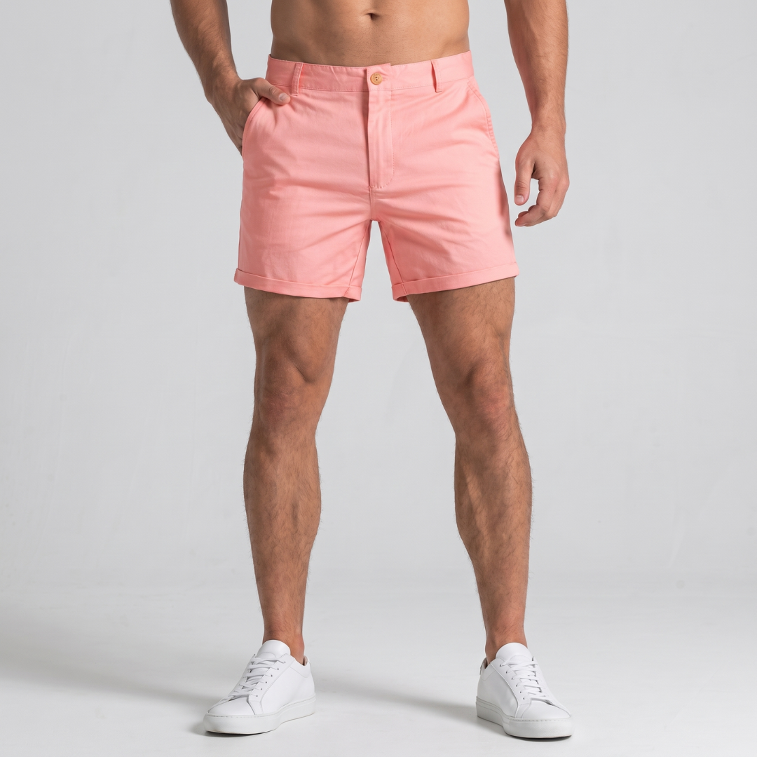 Shorts uomo rosa con orlo risvoltato e tasche laterali, abbinati a sneakers bianche
