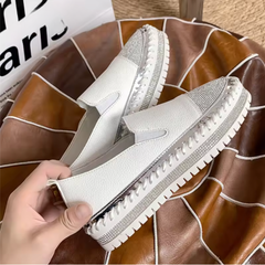 Dettaglio slip-on bianche con inserto elastico laterale e suola platform scanalata