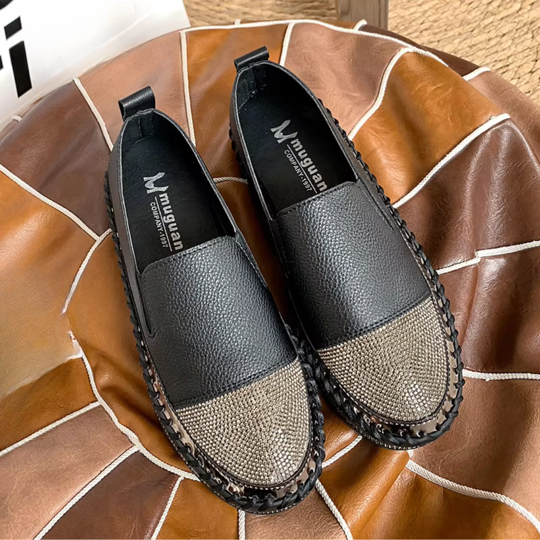 Paio di slip-on nere viste dall'alto, punta ricoperta di strass brillanti