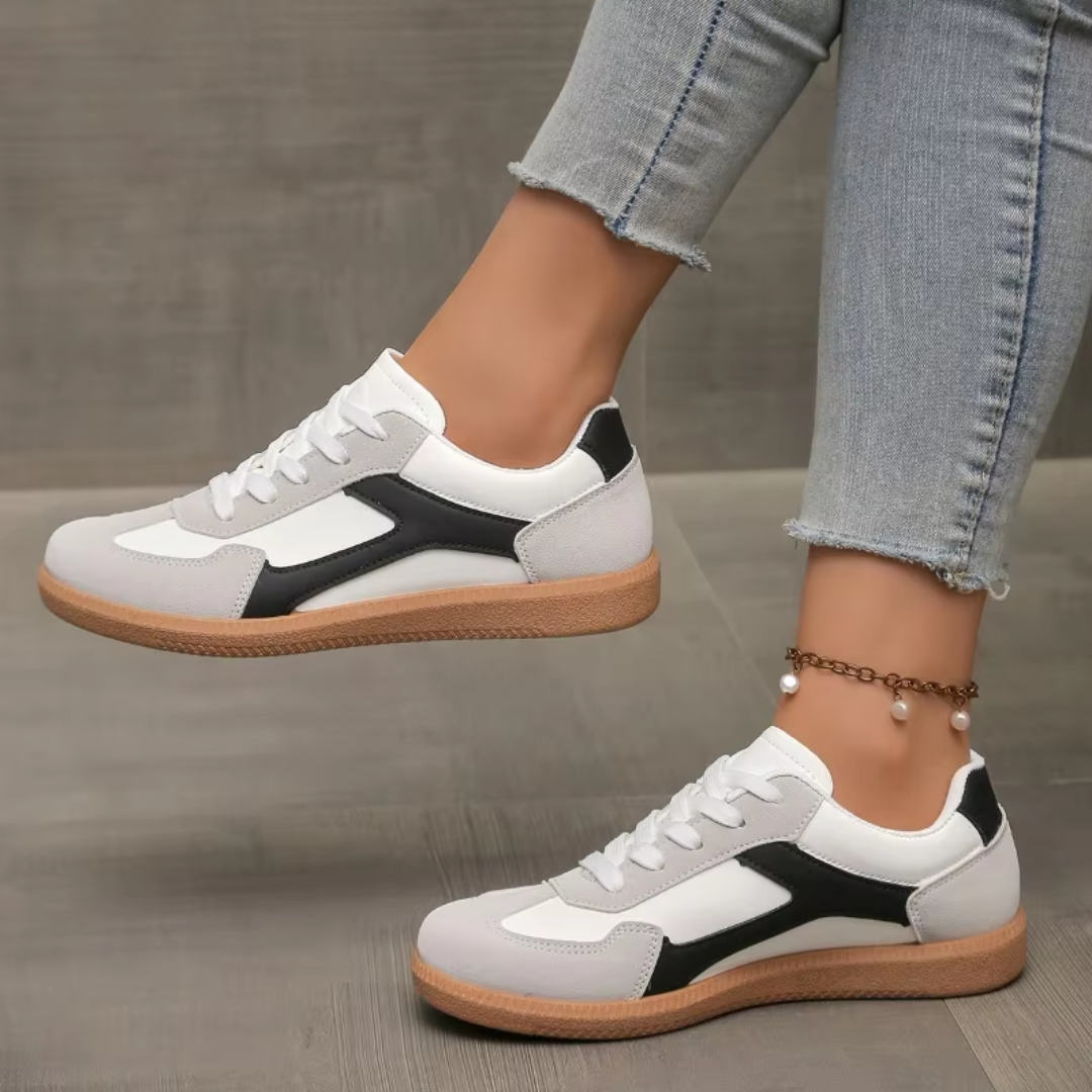 Sneakers donna bianche con inserti neri e grigi, lacci bianchi e suola chiara